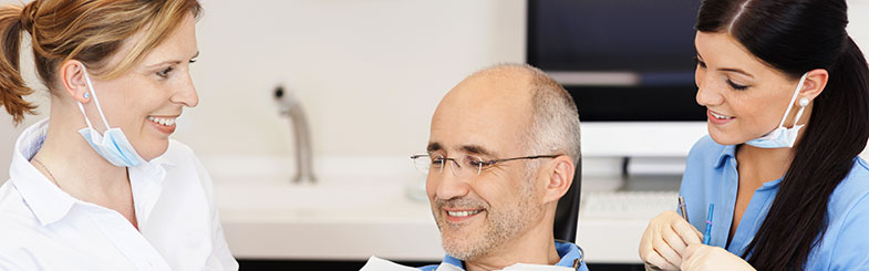 Dental Implantologists with a Smiling Dental Implant Patient